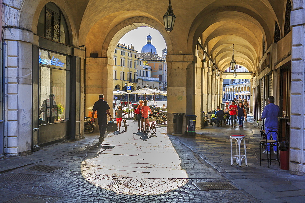 View of Piazza delle Erbe through archways and dome of Padua Cathedral visible, Padua, Veneto, Italy, Europe