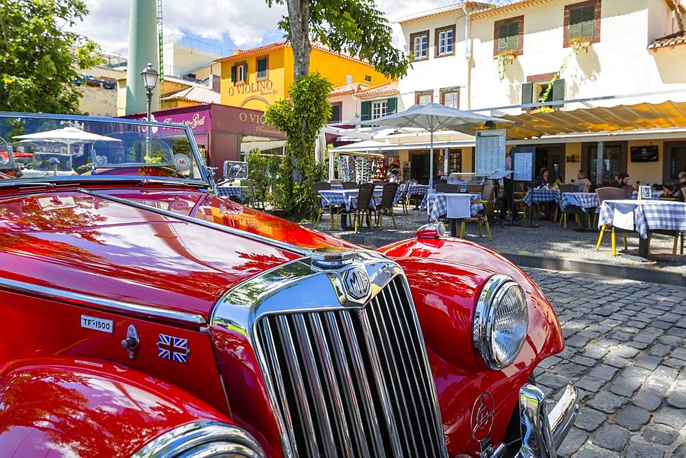 View of red vintage MG car in front of traditional Al Fresco restaurant in old town, Funchal, Madeira, Portugal, Europe