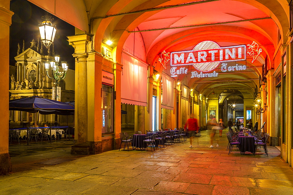 View of Martini Cafe under the arches in shopping arcade at night, Turin, Piedmont, Italy, Europe