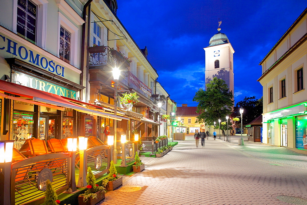 St. Stanislaw and St. Adalbert Parish Church Clock Tower and street scene at dusk, Rzeszow, Poland, Europe