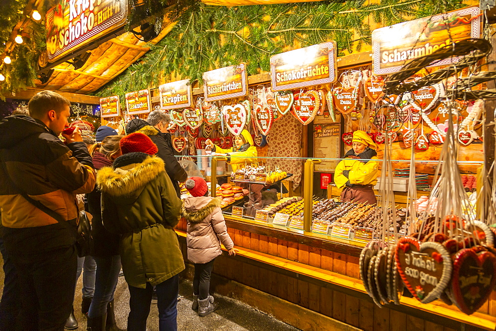 People at Christmas market stall at night in Rathausplatz, Vienna, Austria, Europe