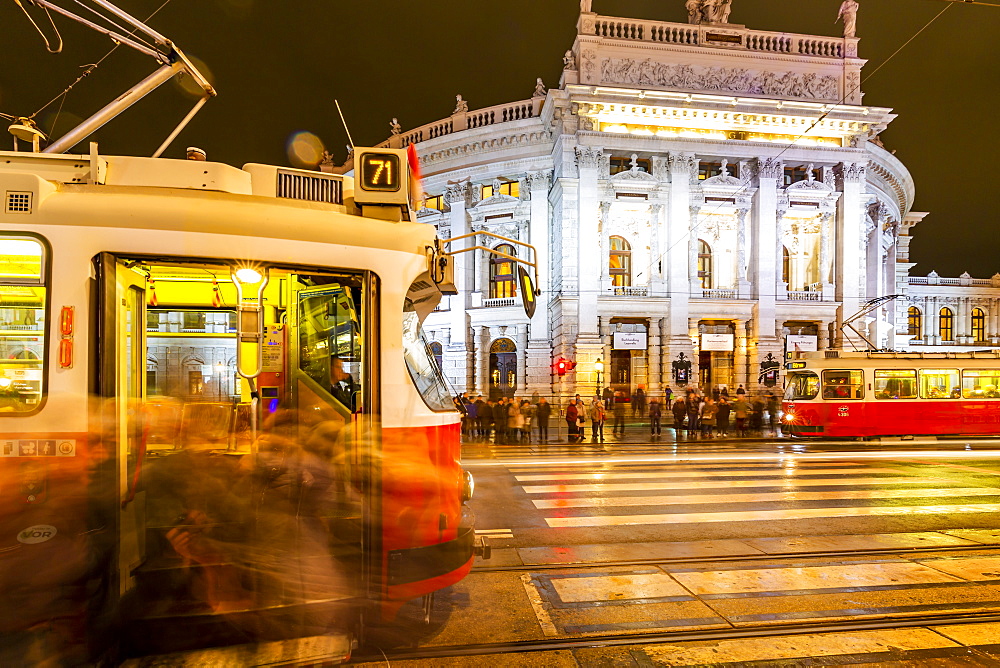 View of Burgtheater and city trams at night in Rathausplaza, Vienna, Austria, Europe