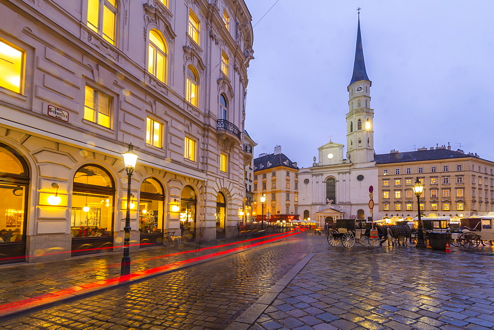 Christmas Market stalls and St. Michael Catholic Church in Michaelerplatz, Vienna, Austria, Europe