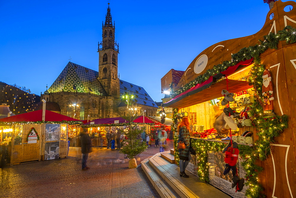 Bolzano Cathedral and long exposure of customers at Christmas Market in Piazza Walther, Bolzano, Italy, Europe