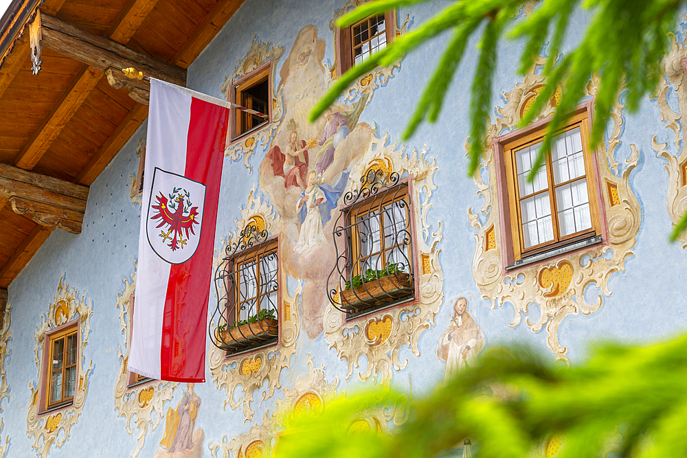 View of Austrian flag and colourful architecture in St. Johann in Tirol, Austrian Tyrol, Austria, Europe