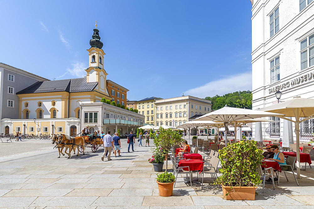 View of St. Michaelskirche and restaurants in Residenzplatz, Salzburg, Austria, Europe