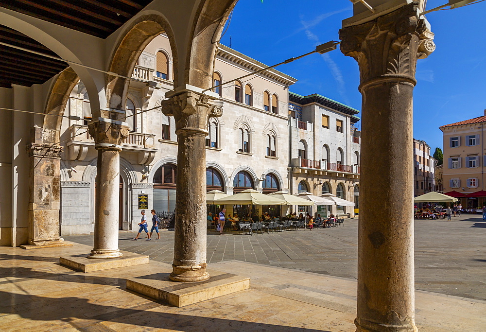 View of cafes from arches of the Town Hall in Forum Square, Pula, Istria County, Croatia, Adriatic, Europe