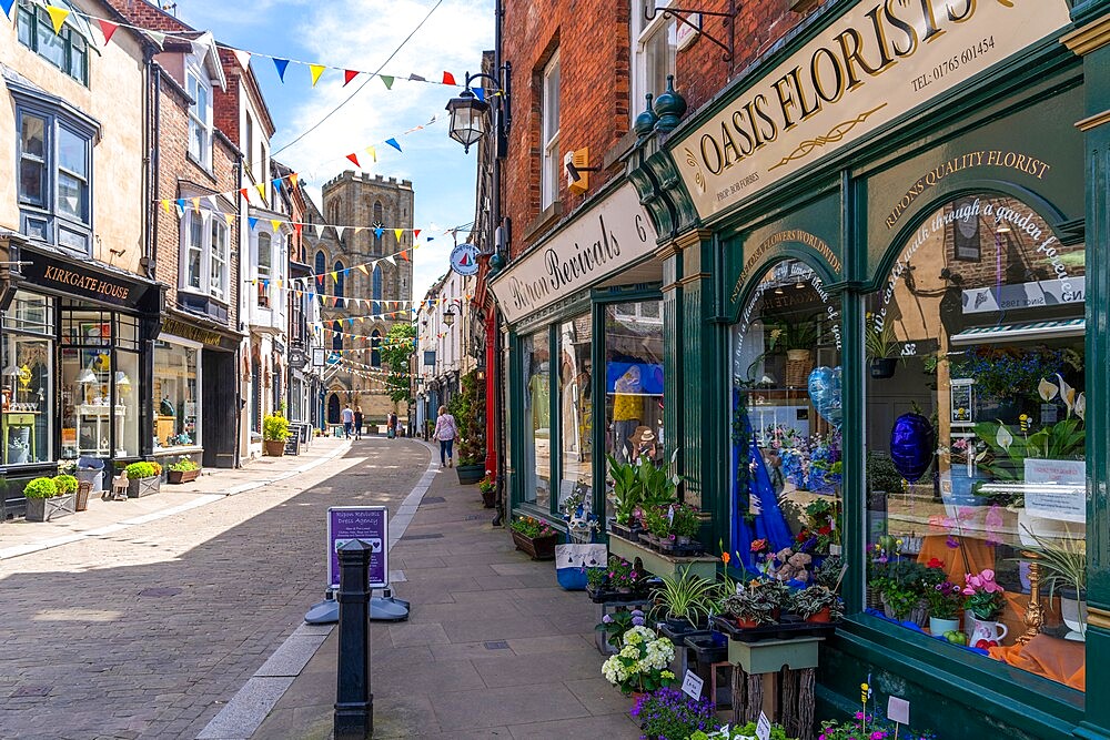 View of shops and cafes on Kirkgate and Cathedral in background, Ripon, North Yorkshire, England, United Kingdom, Europe