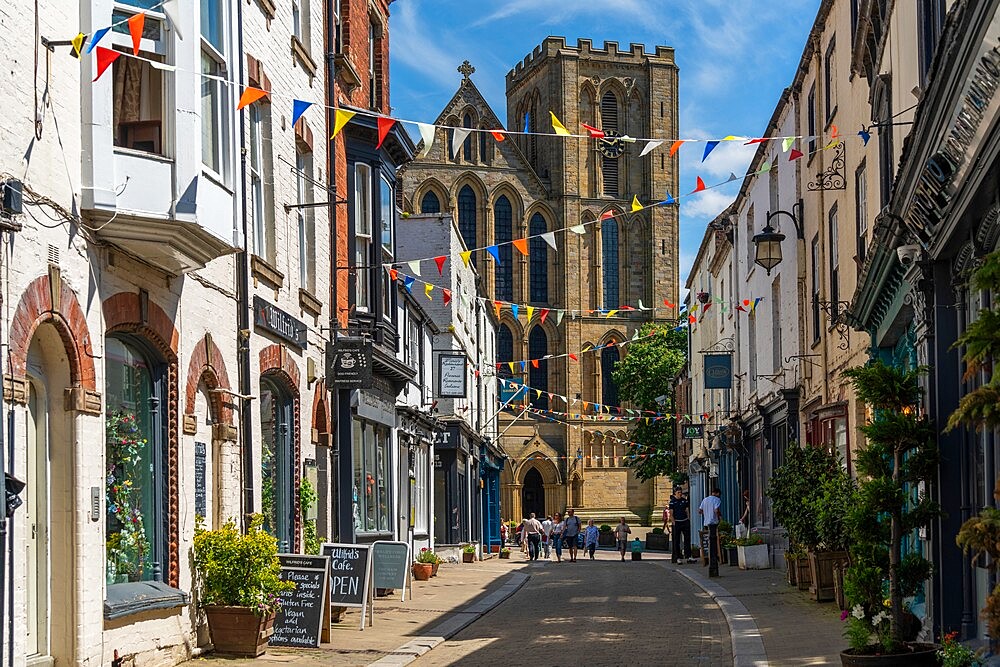 View of shops and cafes on Kirkgate and Cathedral in background, Ripon, North Yorkshire, England, United Kingdom, Europe