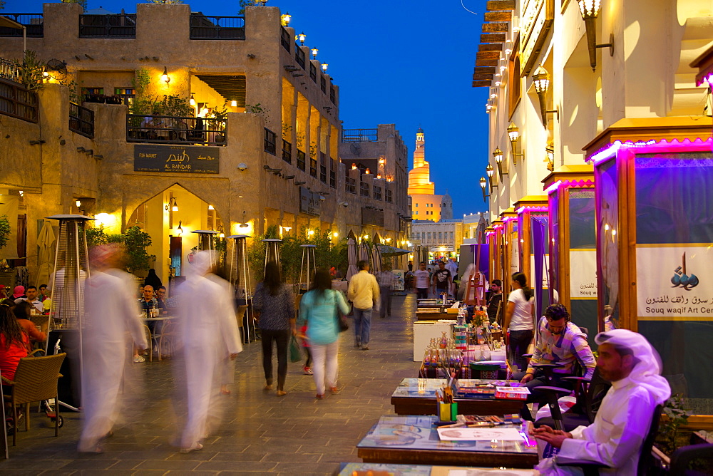 Souq Waqif looking towards the illuminated spiral mosque of the Kassem Darwish Fakhroo Islamic Centre, Doha, Qatar, Middle East