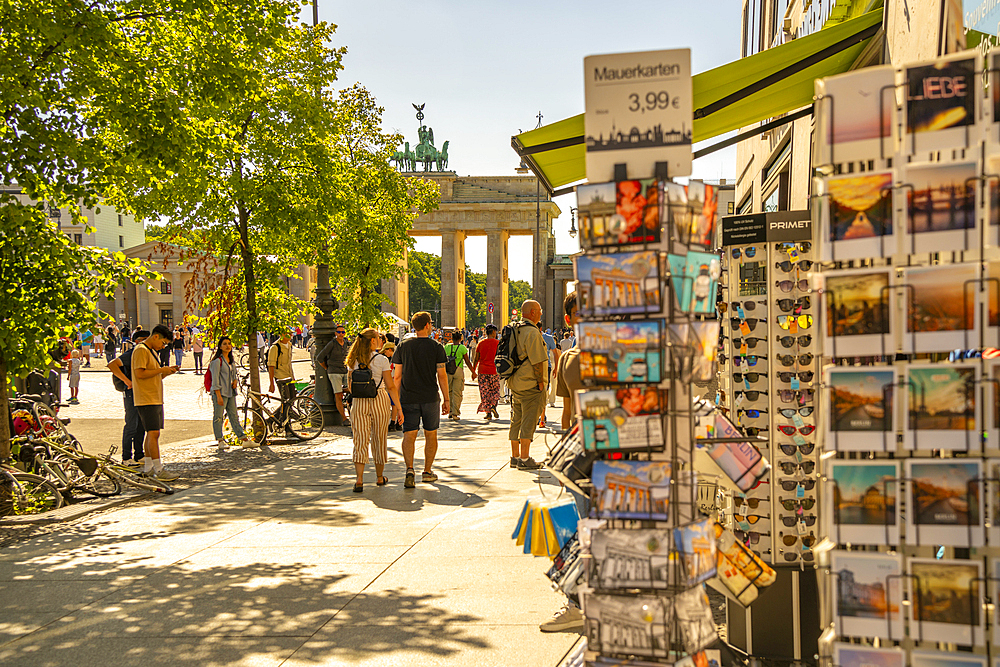 View of Brandenburg Gate, postcards and visitors in Pariser Platz on sunny day, Mitte, Berlin, Germany, Europe