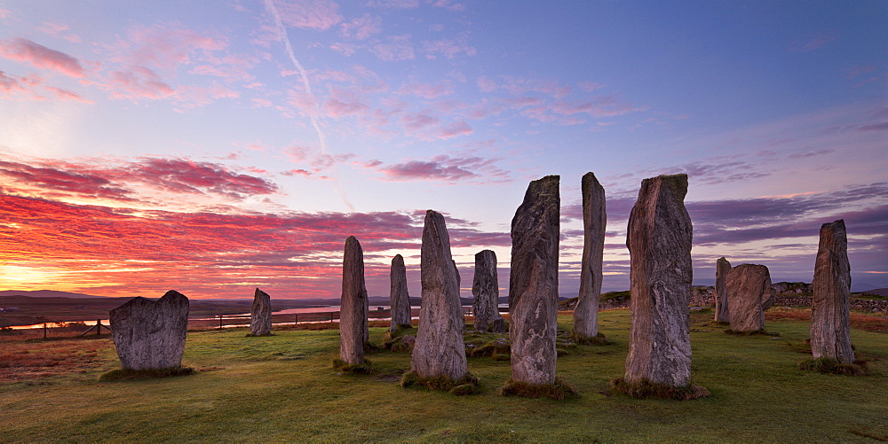 Fiery clouds above the standing stones of Callanish at sunrise in autumn, Island of Lewis, Outer Hebrides, Scotland, United Kingdom, Europe