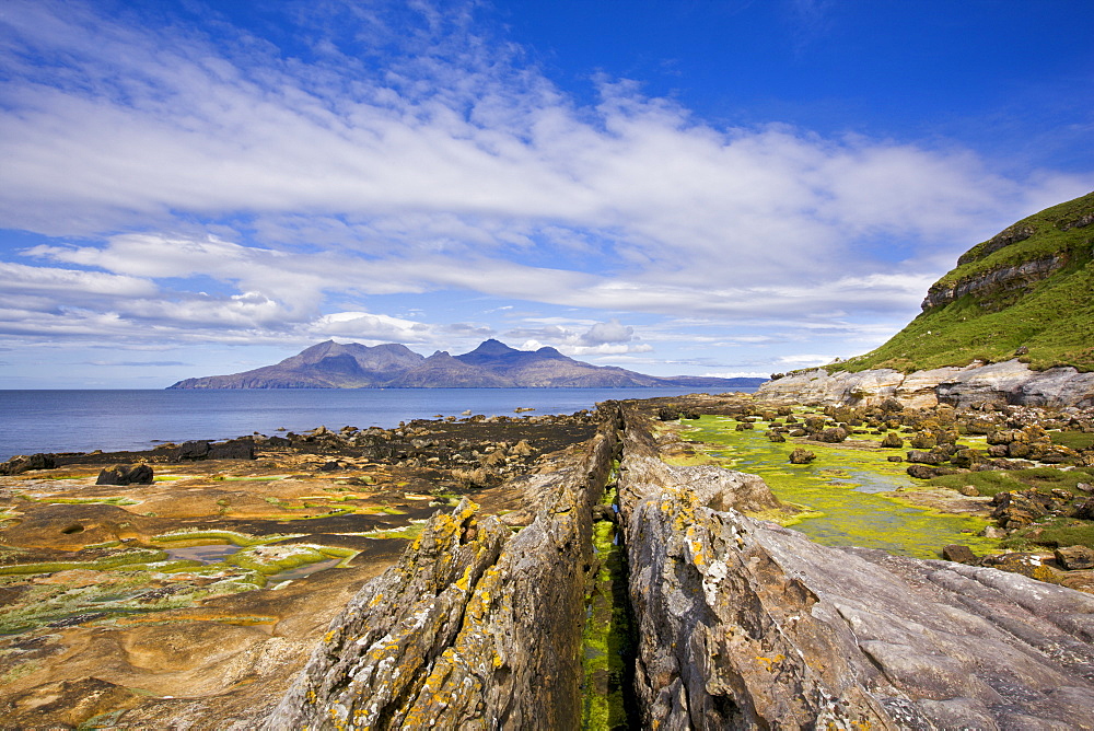 Basalt dyke on Eigg with the Isle of Rum in the distance, Isle of Eigg, Inner Hebrides, Scotland, United Kingdom, Europe