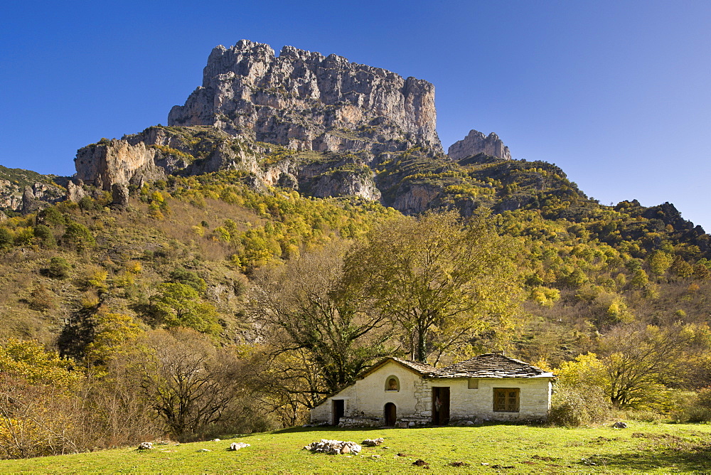 The Panagia Monastery at the bottom of the Vikos Gorge, with the Astraka Peaks above in autumn, Zagoria, Epirus, Greece, Europe