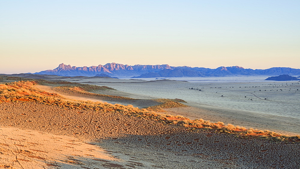 First light on the dunes and mountains of NamibRand, Namib Desert, Namibia, Africa 