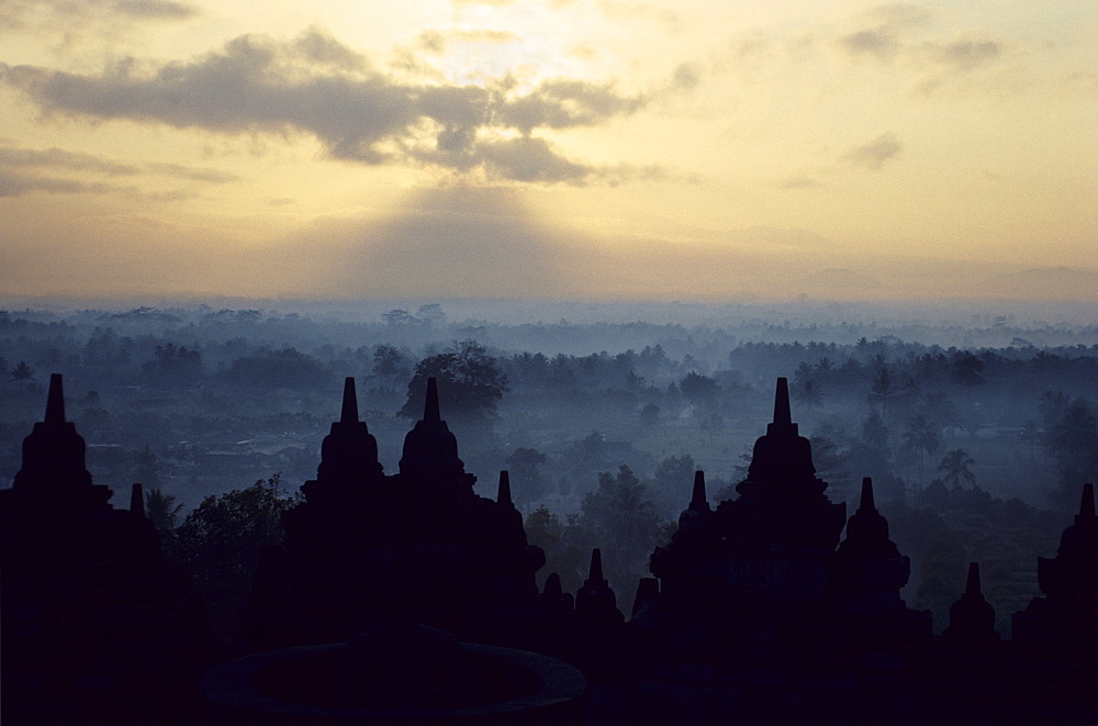 The temple of Borobodur at dawn against a backdrop of mist-shrouded volcanoes, Borobodur, UNESCO World Heritage Site, Java, Indonesia, Southeast Asia, Asia