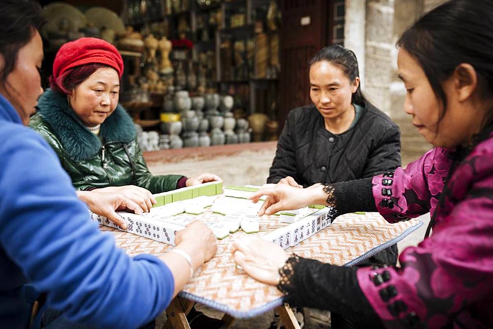 Women playing traditional Chinese game of Mahjong on street, Dali, Yunnan Province, China, Asia