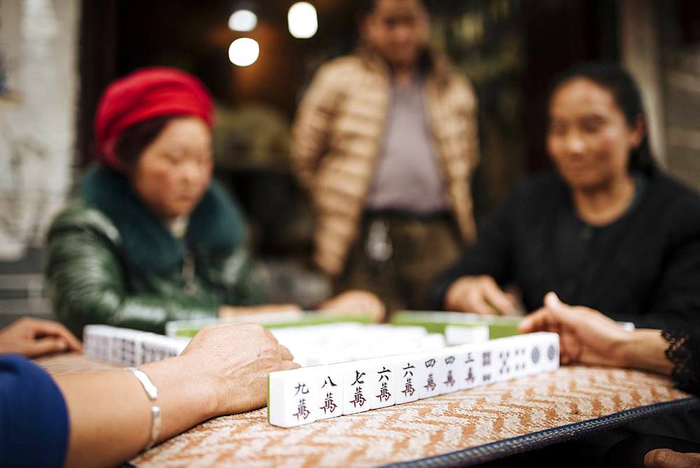 Women playing traditional Chinese game of Mahjong on street, Dali, Yunnan Province, China, Asia