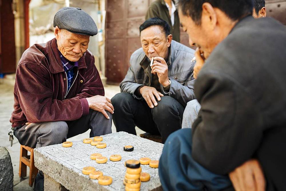 Men playing traditional game of Xiangqi (Chinese Chess), Dali, Yunnan Province, China, Asia