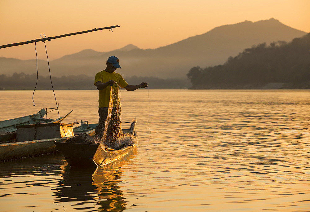 Man reeling in fishing net on Mekong River, Luang Prabang, Laos, Indochina, Southeast Asia, Asia 