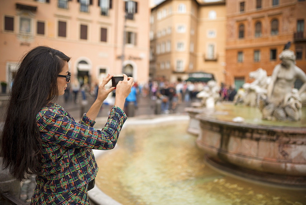 Young woman taking pictures with mobile phone, Piazza Navona, Rome, Lazio, Italy, Europe