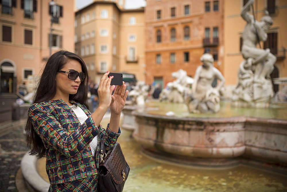 Young woman taking pictures with mobile phone, Piazza Navona, Rome, Lazio, Italy, Europe