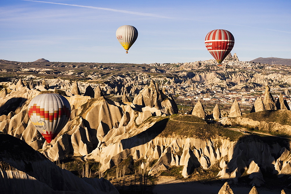 Hot air balloons flying among rock formations at sunrise in the Red Valley, Goreme National Park, UNESCO World Heritage Site, Cappadocia, Anatolia, Turkey, Asia Minor, Eurasia