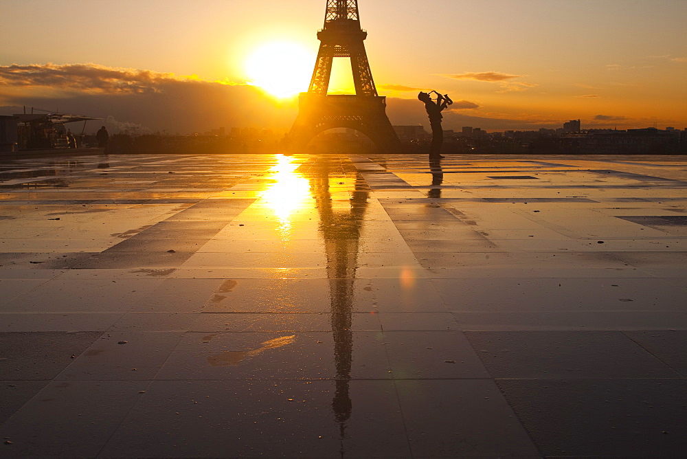 A man playing a trumpet in front of the Eiffel Tower, Paris, France, Europe