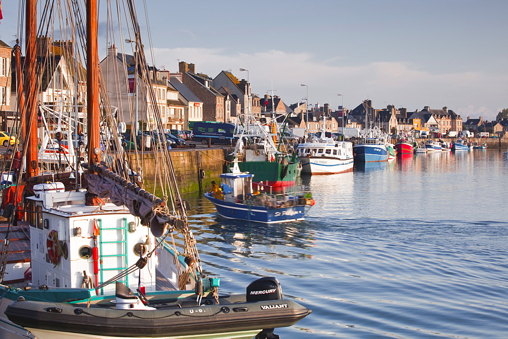 The Fleur de Lampaul, a protected historic monumen in the foreground, and small boat in the harbour at Saint Vaast La Hougue, Cotentin Peninsula, Normandy, France, Europe