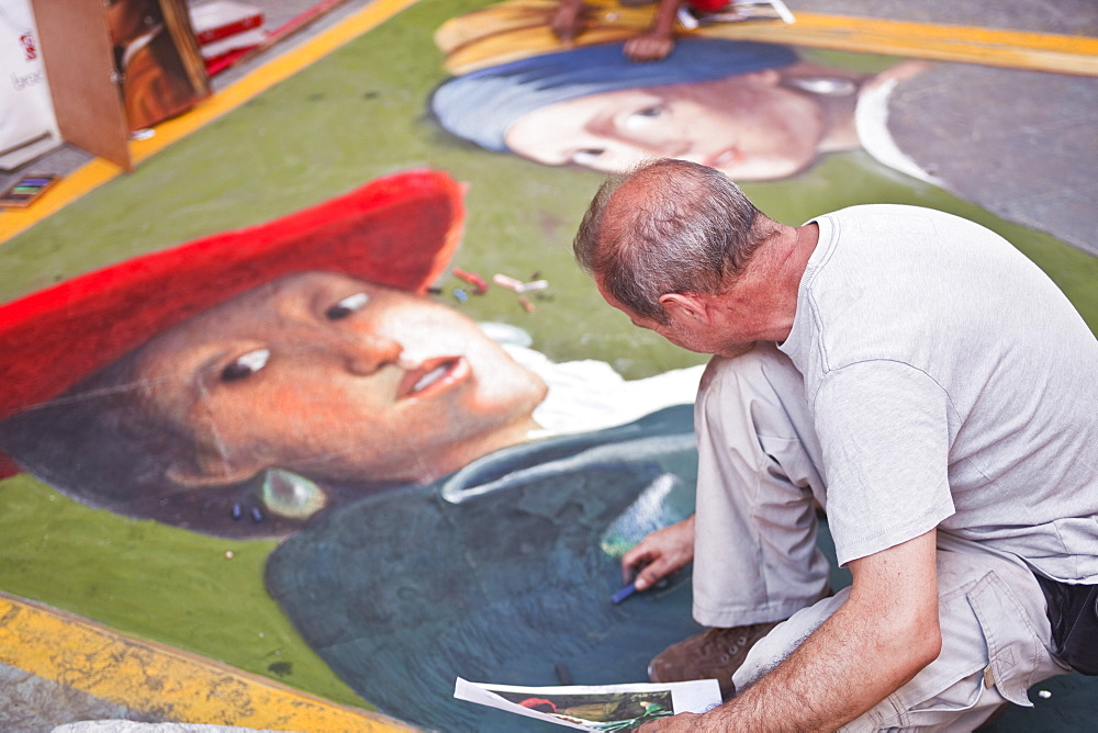 An artist draws on the streets of Florence, Tuscany, Italy, Europe