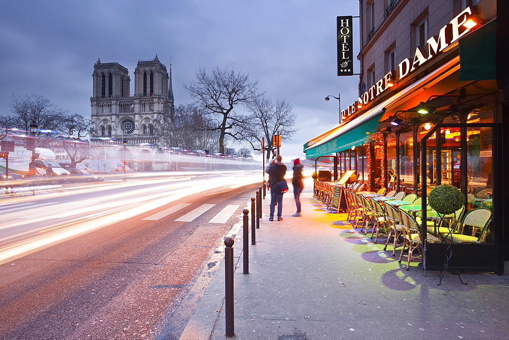 Tourists stop to photograph Notre Dame de Paris cathedral at dawn, Paris, France, Europe