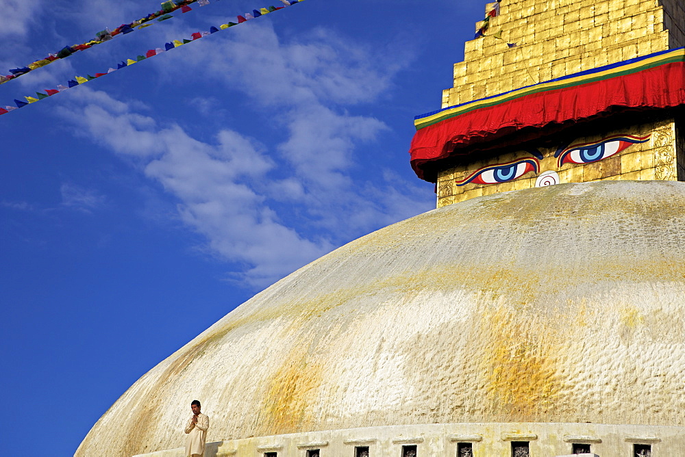 Man praying in front of the dome of Boudha (Bodhnath) (Boudhanath) stupa, Kathmandu, UNESCO World Heritage Site, Nepal, Asia