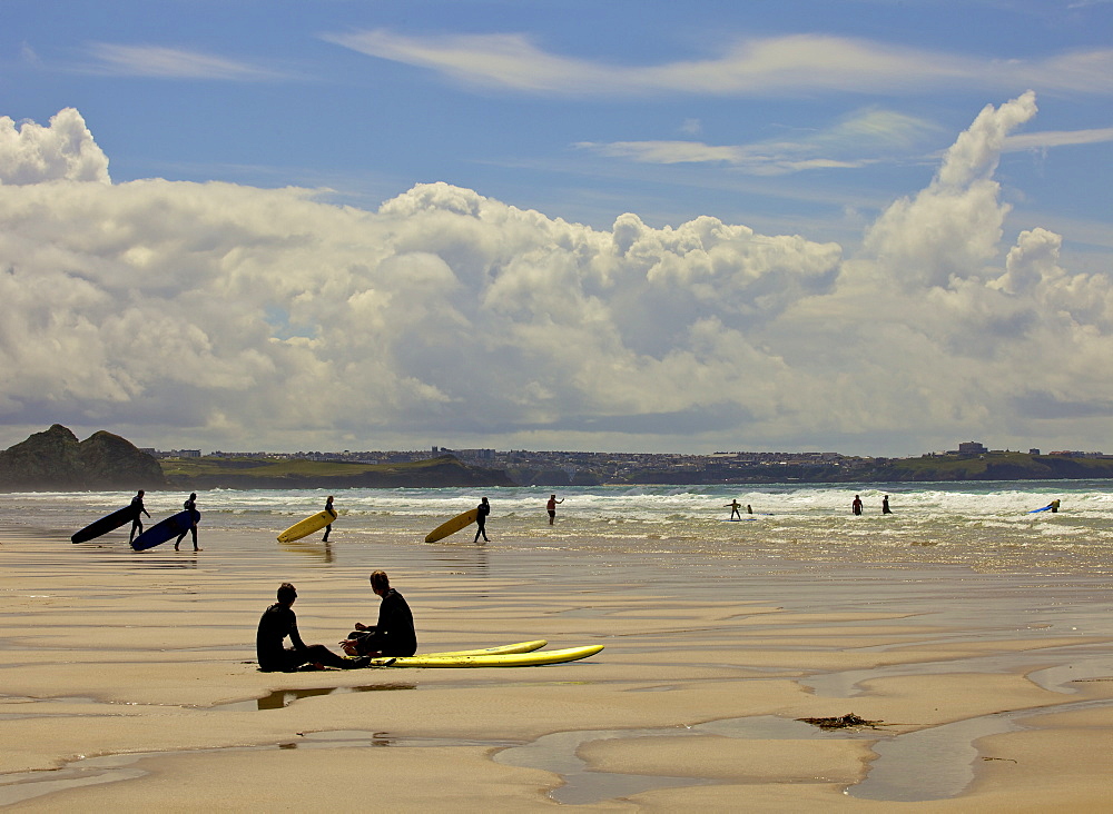 Surfers with boards on Perranporth beach, Cornwall, England