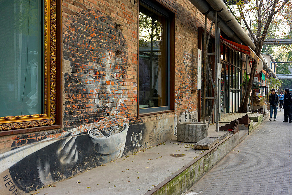 Young girl eating noodles, graffitied on a wall at the 798 Art Zone (Dashanzi Art District) in Beijing, China, Asia