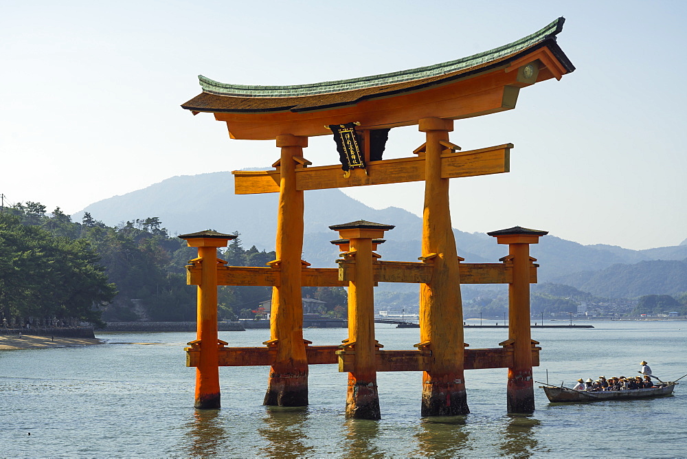 Tourist passing through the floating red wooden torii gate of Miyajima, Itsukushima, UNESCO World Heritage Site, Hiroshima Prefecture, Honshu, Japan, Asia