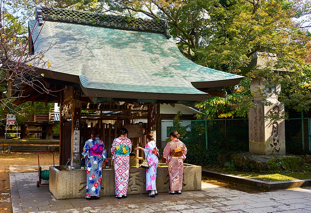 Japanese women in kimonos washing hands before entering the Tenmangu Shrine, Kyoto, Japan, Asia