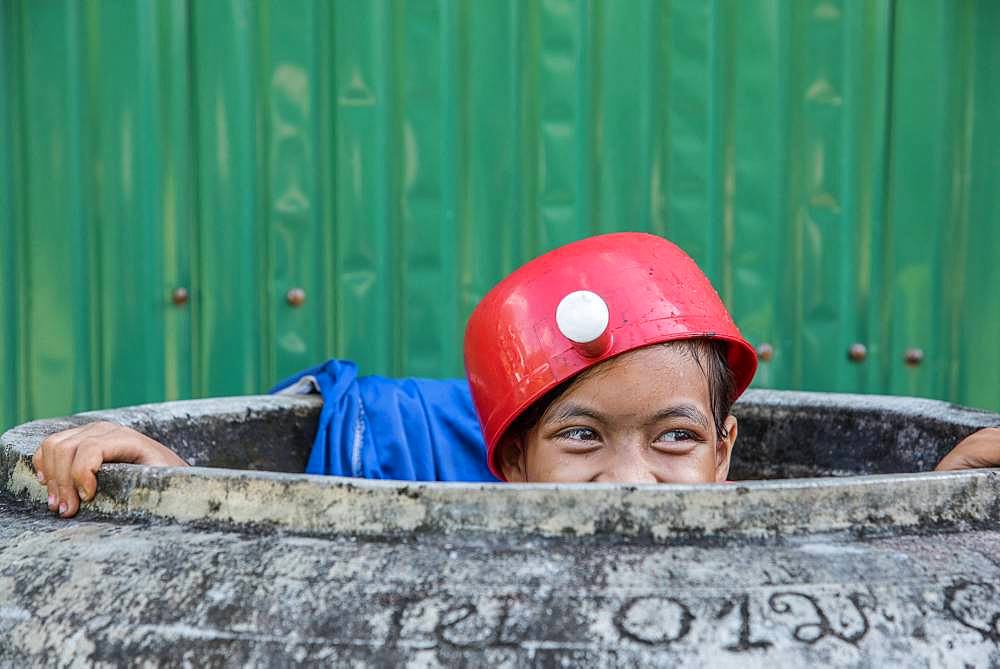 Child or teenager with hat, cap or object on his head.