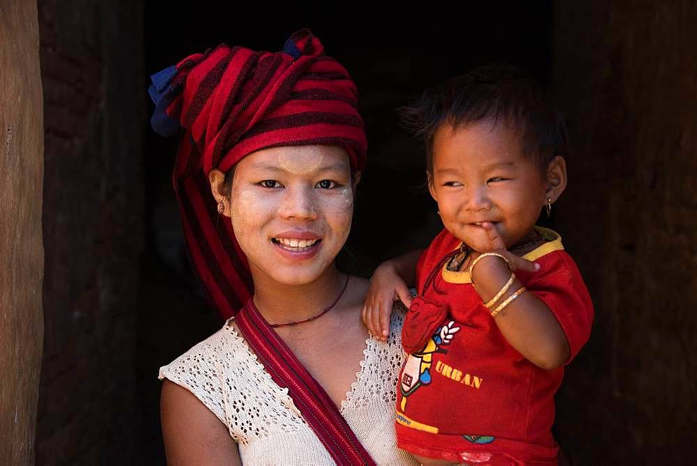 Burmese girl of Pao ethnic group carrying her little sister in the city of Nyuang U