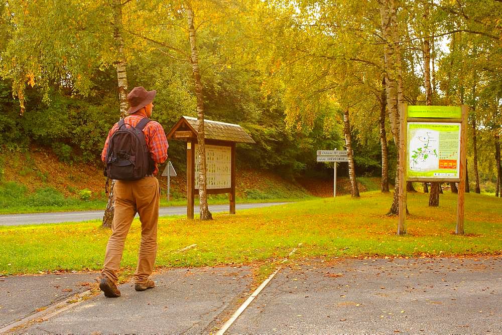 Walker walking on a green stream following an old abandoned railway line connecting Beauvais to Amiens - in autumn, Picardy, France.