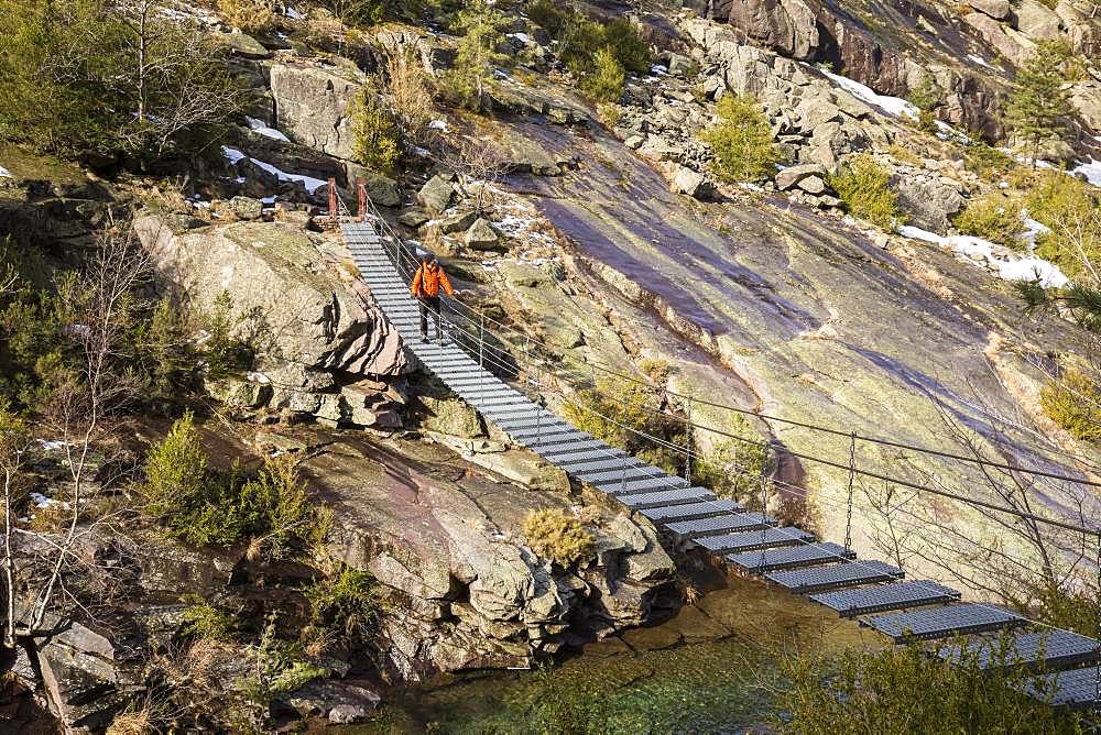 Hiker on the suspended footbridge of Spasimata on the GR 20, Cirque de Bonifatu, Corsica Regional Nature Park, Balagne, Corse-du-Sud, France