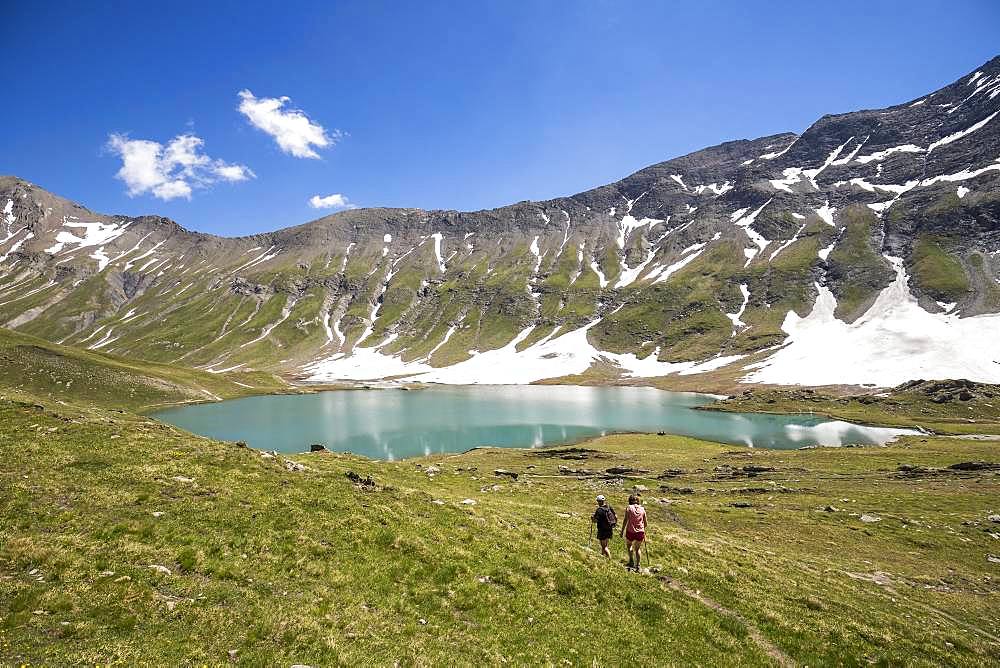 A couple of hikers walk to Lake Goleon (2438m) in the Oisans massif, ecrins National Park, Hautes-Alpes, France