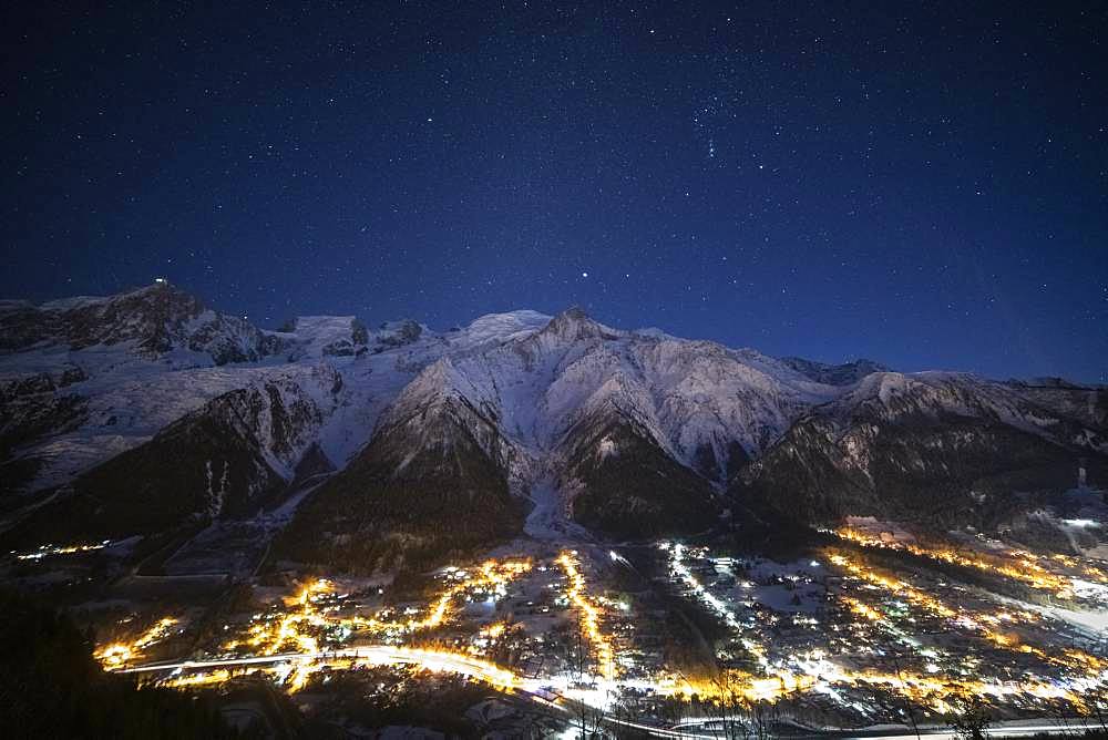 Sea of clouds lit by the Arve valley, by night, and Milky Way, facing the Mole mountain, the Aravis massif, and the Brasses massif, Alps, France