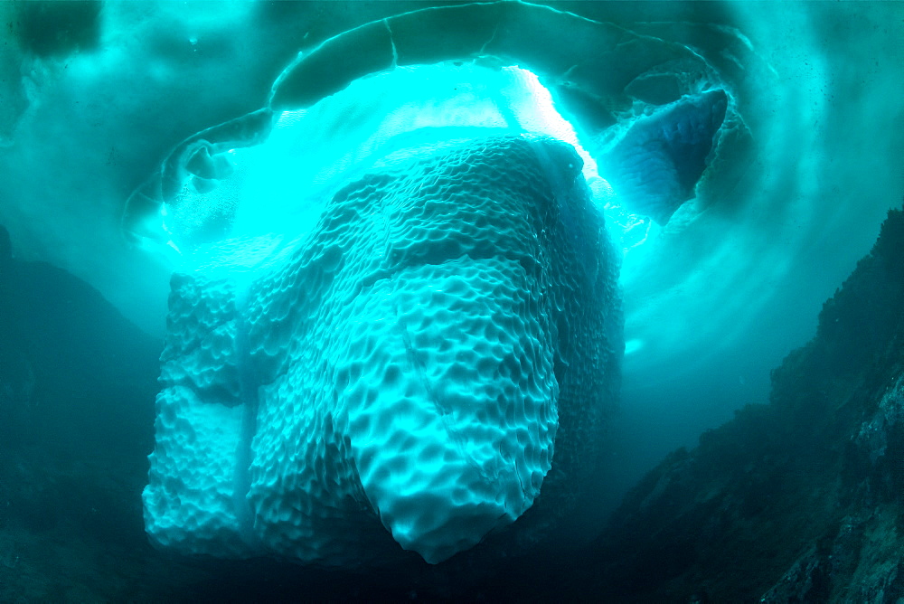 Only in springtime, when the hard winter slowly subsides, are the ice-cold waters suitable for divers who can dive around a iceberg that floats in crystal-clear water, Tasiilaq, East Greenland