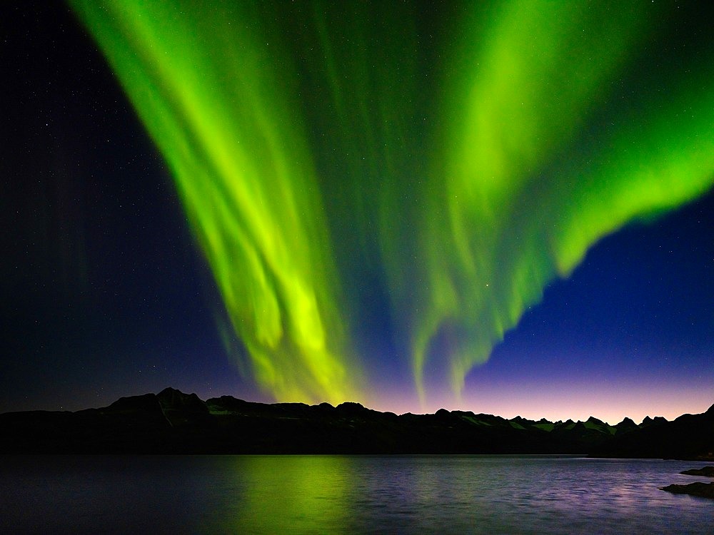 Northern lights over Angmagssalik Fjord near settlement Kuummiit (formerly spelled Kummiut). Ammassalik area in East Greenland. North America, Greenland, Danish Territorrry