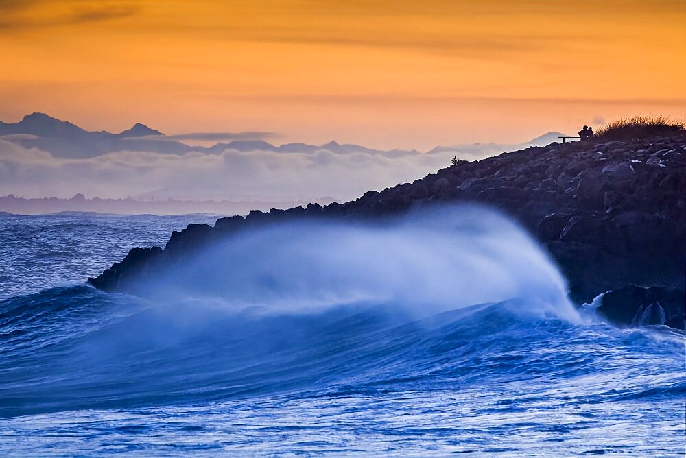 Waves breaking on the rocks of the corniche at sunset, storm on Sete, Herault, Languedoc-Roussillon, France