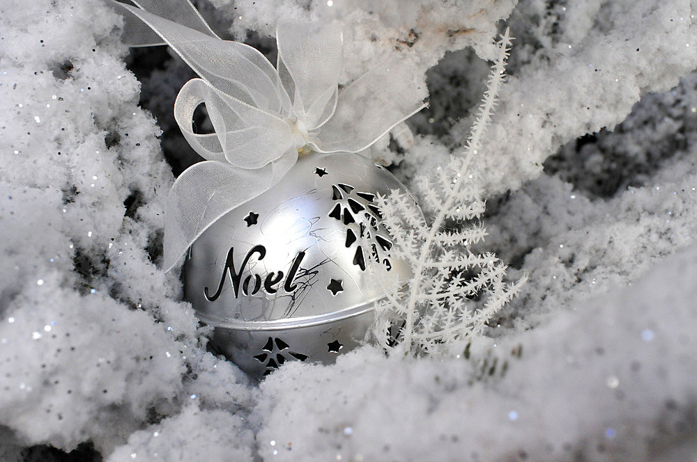 Christmas ball with ribbon, festive decoration, tree covered with artificial snow