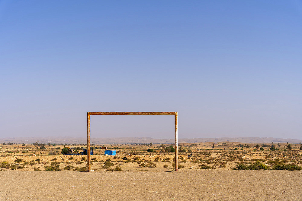 Soccer stadium cage in the desert and desert landscape. Tunisian desert, Tounket, Tunisia.