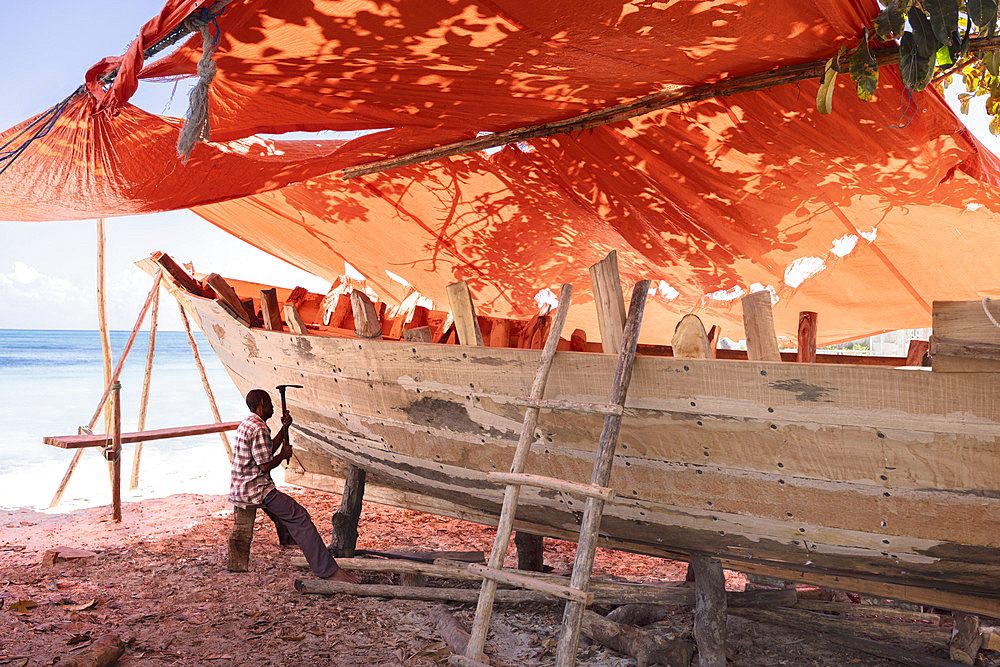 Craftsman building a dhow on a beach at Nungwi in the north of the island of Zanzibar, Tanzania