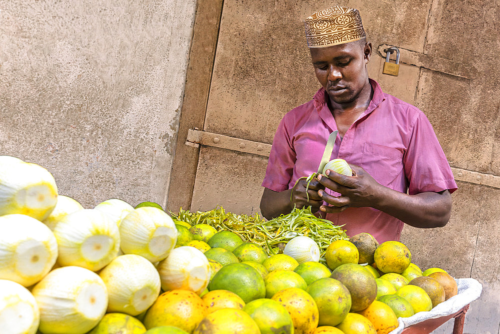 Man selling oranges, a local variety that can only be eaten peeled. Stone Town, Zanzibar, Tanzania