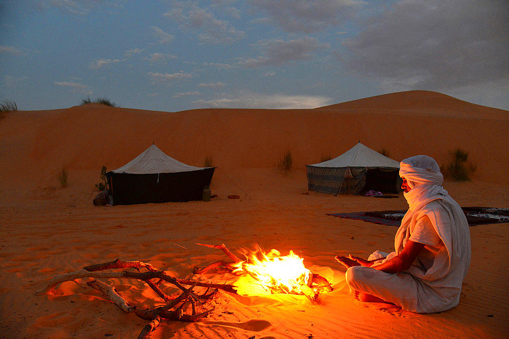 Mauritanian travel guide making fire at night at a camp in the desert.. Chinguetti. Ancient ksour of Ouadane, Chinguetti, Tichitt and Oualata. Adrar. Mauritania